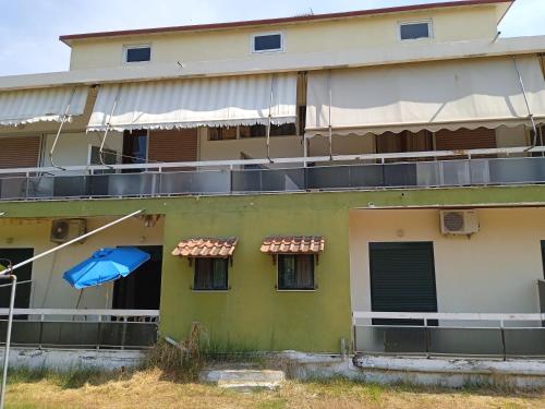 a building with a blue umbrella on the side of it at PANAGIOTIS in Pefki