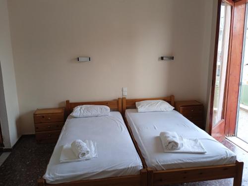 two twin beds in a room with a window at PANAGIOTIS in Pefki
