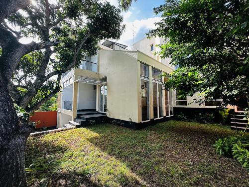 una casa con un árbol delante de ella en Mango Tree Villa, en Sri Jayewardenepura Kotte