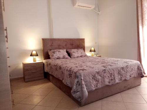 ein Schlafzimmer mit einem großen Bett und zwei Nachttischen in der Unterkunft Ιδανικό διαμέρισμα δίπλα στο μετρό, ανάμεσα στο κέντρο και τη παραλία in Athen