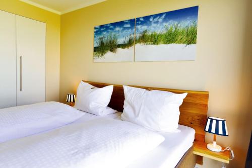 duas camas num quarto de hotel com almofadas brancas em Haus Horizont H511 em Cuxhaven