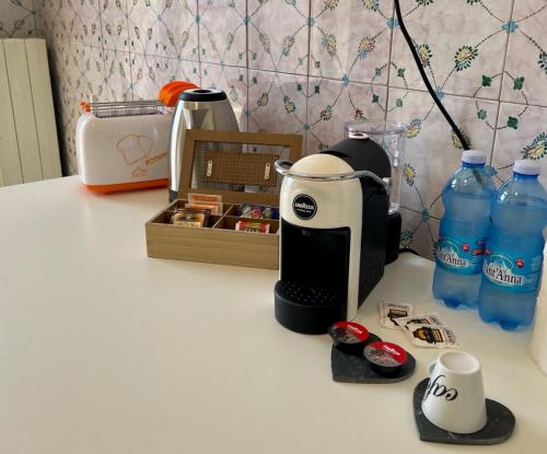a coffee maker on a counter with bottles of water at Le Ville Tivoli - Suites, Tivoli City Center! in Tivoli