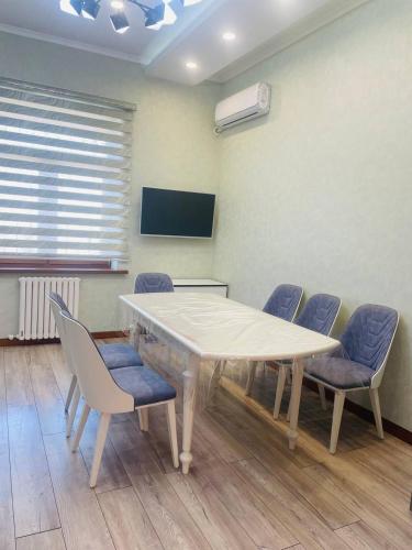 Sala de conferencias con mesa, sillas y TV en Center luxury Apartment is situated in Tashkent., en Yakkasaray
