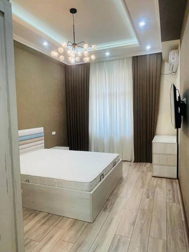 ein Schlafzimmer mit einem großen weißen Bett in einem Zimmer in der Unterkunft Center luxury Apartment is situated in Tashkent. in Yakkasaray