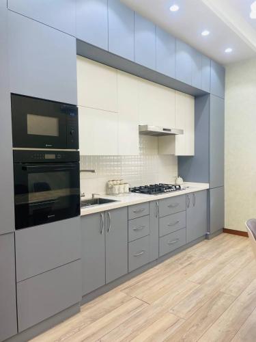 cocina con armarios blancos y fogones en Center luxury Apartment is situated in Tashkent., en Yakkasaray