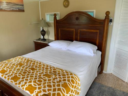 a bedroom with a large bed with a wooden headboard at Sunrise Suite in Gros Islet