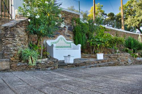 a bench sitting next to a brick wall with plants at Monte Alecrim in Alandroal
