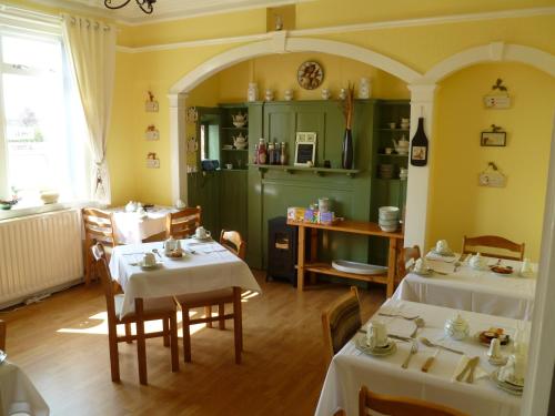 una habitación con dos mesas con manteles blancos en Greenlaw Guest House, en Gretna Green