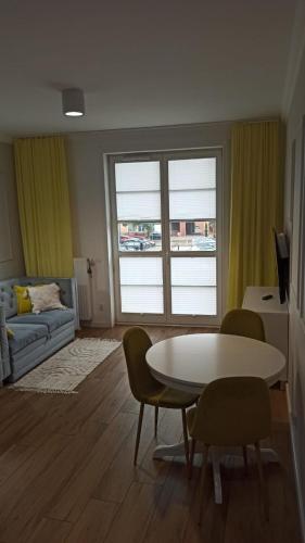 uma sala de estar com uma mesa e cadeiras e um sofá em Apartament na Starówce em Elblag