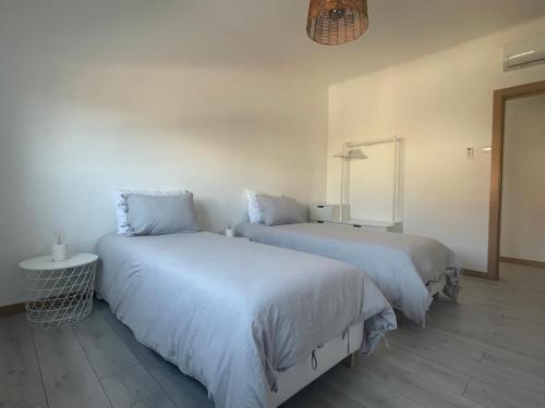 two beds sitting next to each other in a room at Puro São Jacinto in Aveiro