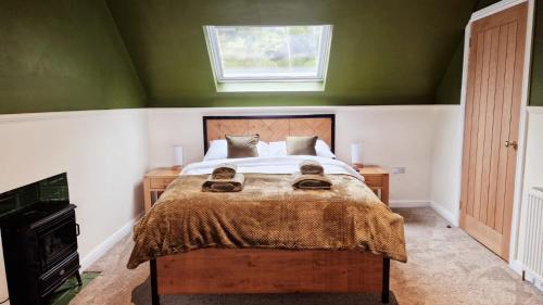 a bedroom with a bed with green walls and a window at Nordlys Cottage in Newton Stewart