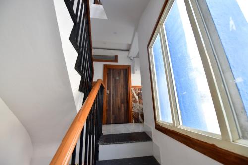 a staircase with a large window and a door at Hotel Surya Lodge in Mysore