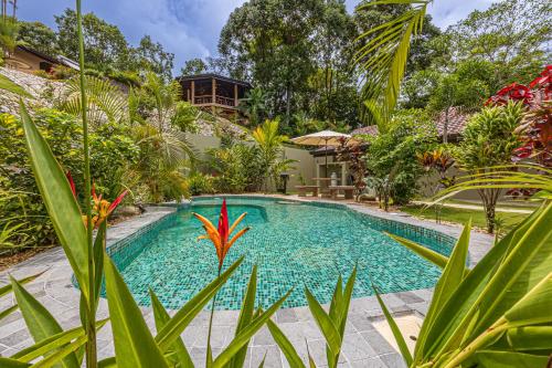 a swimming pool in the middle of a garden at The Garden Villas by Vista Celestial in Uvita