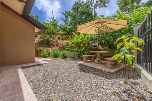 a patio with a bench and an umbrella at The Garden Villas by Vista Celestial in Uvita