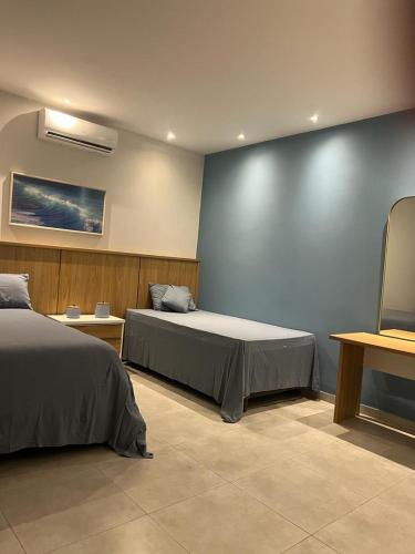 sypialnia z 2 łóżkami i niebieską ścianą w obiekcie Casa por temporada w mieście Santarém