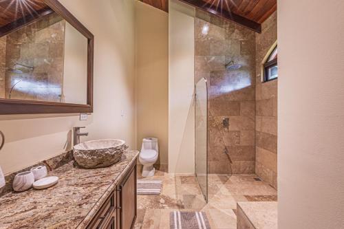 a bathroom with a shower and a sink and a toilet at The Garden Villas by Vista Celestial in Uvita