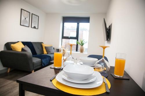 a living room with a table with plates and glasses at Luxurious City Center 1 BR Vibrant Liverpool in Liverpool