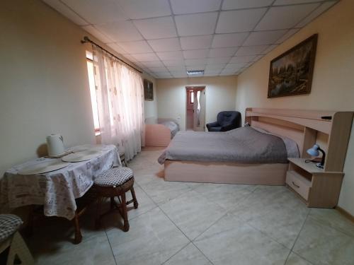 a bedroom with a bed and a table and chairs at КОМФОРТ in Karpaty