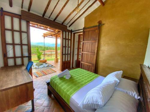 una camera con un letto e una coperta verde di Cabaña Villa Chelita descanso y confort. a Barichara
