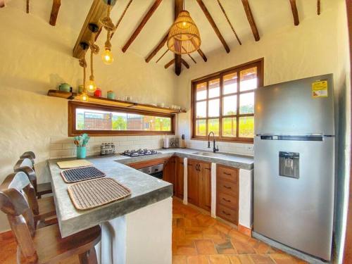una grande cucina con frigorifero in acciaio inossidabile di Cabaña Villa Chelita descanso y confort. a Barichara