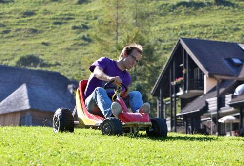 a man riding on a toy car in a field at Joli studio au pied du Moleson in Gruyères