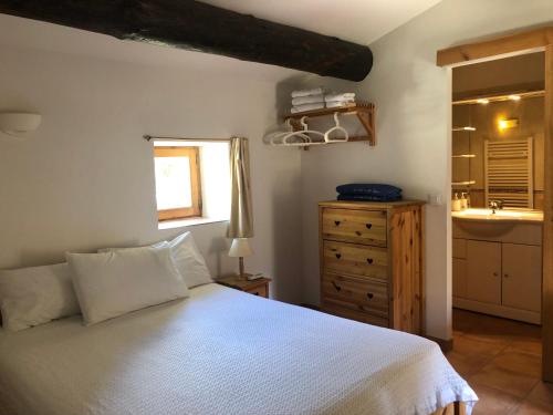 a bedroom with a white bed and a sink at LA BOULANGERIE in Saint-Sauveur-de-Cruzières