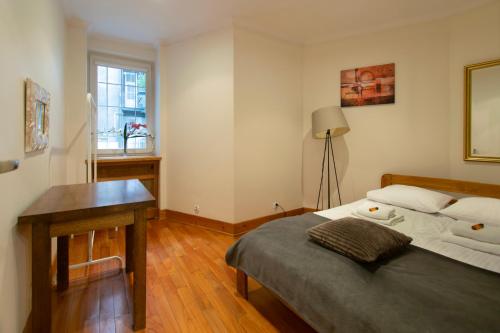 a bedroom with a bed and a desk and a window at Stylish 2 bedroom apartment Morsztynowska street in Krakow