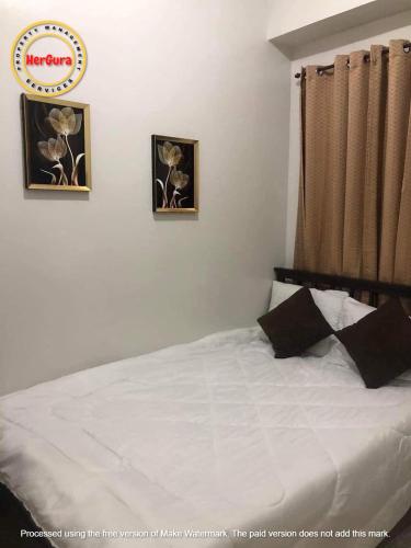 una camera con un letto con due immagini sul muro di Trees Residences 2 Bedroom Unit T21 by HerGura PMS a Manila