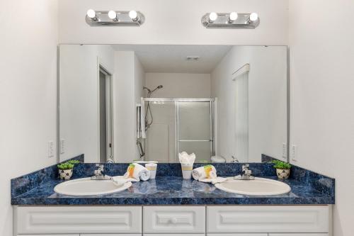 a bathroom with two sinks and a large mirror at Triple En-Suite Pool Retreat - All Master Bedrooms in Inverness