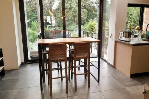 eine Küche mit einem Holztisch und einigen Stühlen in der Unterkunft Grd maison 6 Couchages, 25 mn du stade en métro in Lambersart