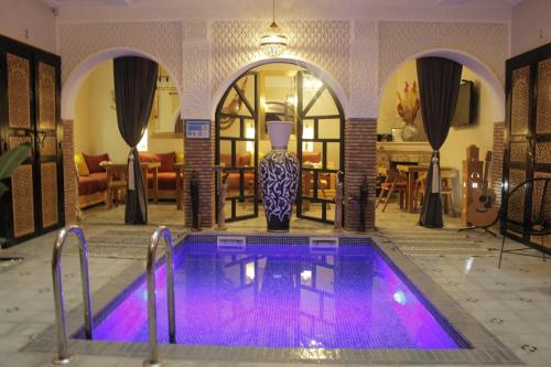 een zwembad met paarse verlichting in de woonkamer bij Riad Les Gazelles D'Orient Marrakech in Marrakesh