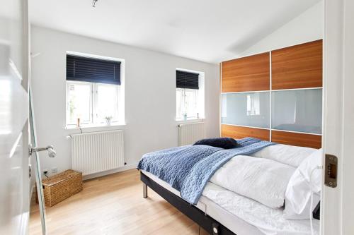 a bedroom with a large bed with a wooden headboard at Charmerende lejlighed in Fredericia