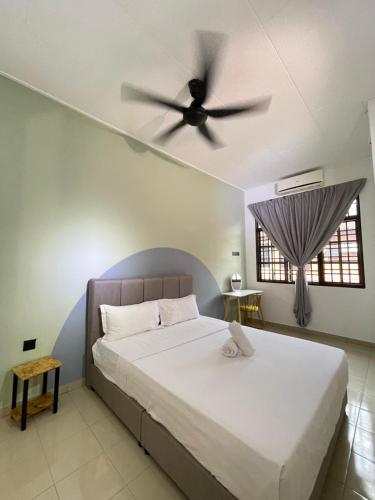 a bedroom with a bed with a ceiling fan at Unique 4 Bedrooms House, Few mins to Town by Mr Homestay in Teluk Intan