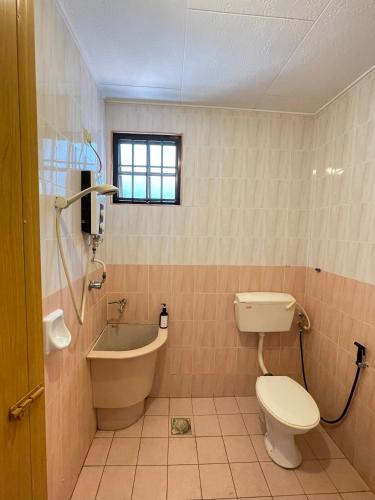 a bathroom with a toilet and a tub and a sink at Unique 4 Bedrooms House, Few mins to Town by Mr Homestay in Teluk Intan