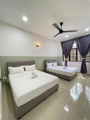 a bedroom with two beds and a ceiling fan at Unique 4 Bedrooms House, Few mins to Town by Mr Homestay in Teluk Intan