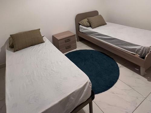 Duas camas num quarto com um tapete azul em 3 bedroom apartment in Marsascala em Marsaskala