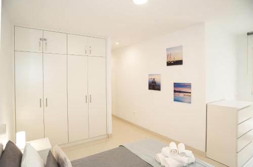 a white bedroom with white cabinets and a bed at Casa Brillante in Playa de San Juan