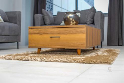 a wooden coffee table in a living room with a vase on it at LAVIDA in Abidjan