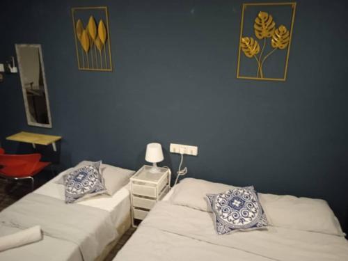 two beds in a room with blue walls at Wayton Express in George Town