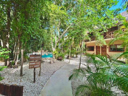 a walkway in front of a building with a sign at Aldea Xaan Ha Tulum in Tulum