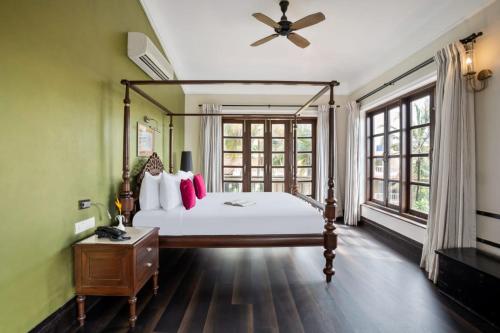 a bedroom with a bed and a large window at Sol De Goa in Nerul