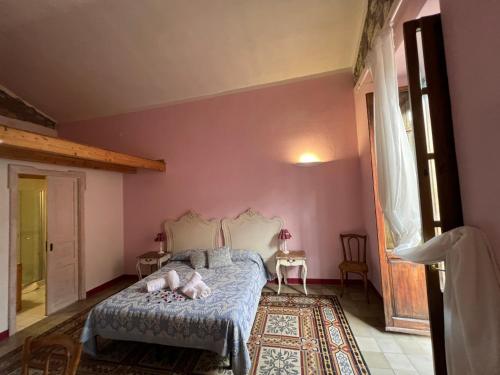 a bedroom with pink walls and a bed in a room at Corso 41 in Bosa
