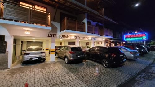 un estacionamiento con autos estacionados frente a un edificio en Pousada Ana do Forte, en Praia do Forte