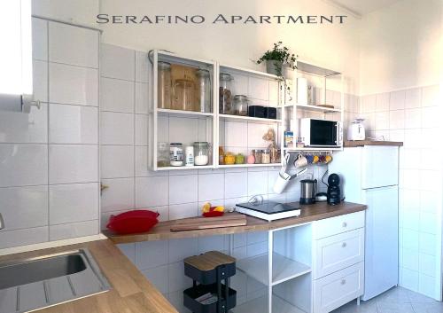 cocina con paredes de azulejos blancos y armarios blancos en The 6th floor flat - direct link to centre in 8 mins en Milán