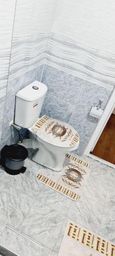 a bathroom with a toilet in a tile floor at sheykh hotel in Andizhan