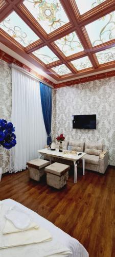 Camera con soffitto a cassettoni, tavolo e divano. di sheykh hotel a Andizhan