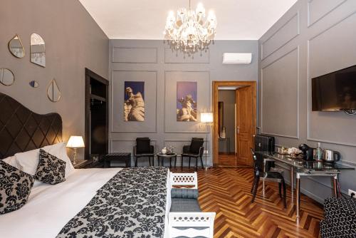 a bedroom with a bed and a desk and a chandelier at Maison Rêve Torino Centro in Turin