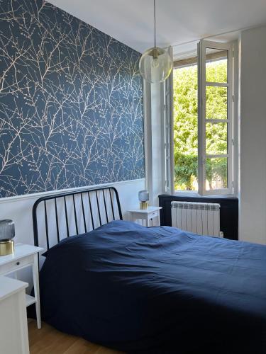 een slaapkamer met een blauw bed en een blauwe muur bij Bright Apt 70m2 in Bayeux historic center w Pkg in Bayeux