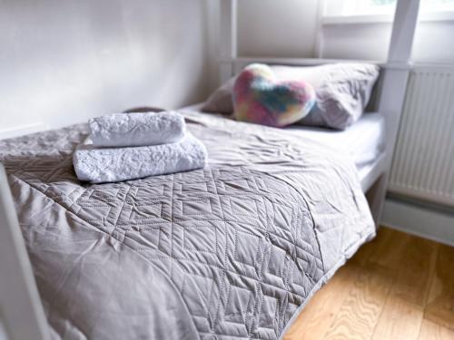 a bed with three pillows on top of it at Cosy apartment in London
