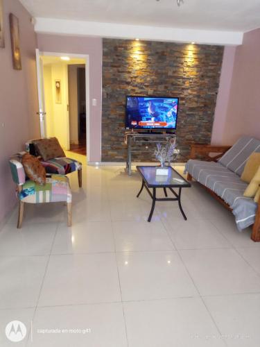 sala de estar con sofá y TV en Santa Rosa en Mendoza